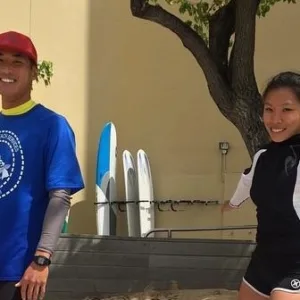 Valet assisting guests with water activity equipment on beach