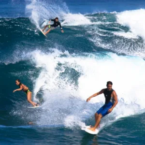 Surfers catching waves on the North Shore beach