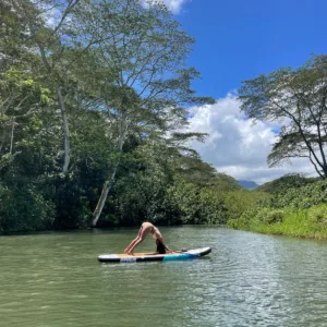 Participants practicing yoga on paddleboards in calm waters