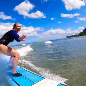 Instructor giving private surf lesson at sunset beach