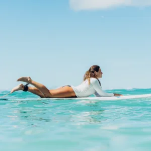 Adult receiving private surf lesson on calm beach waves