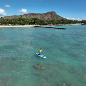 Paddleboarder learning balance on calm ocean waters