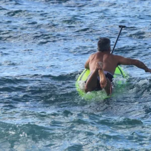 Instructor teaching stand up paddle surfing on calm water