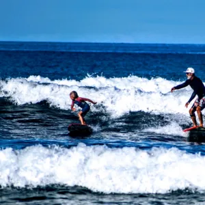 Instructor teaching surf lesson to individual surfer