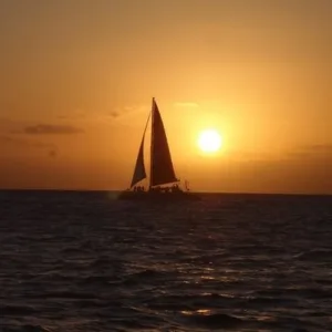 Boat sailing at sunset with passengers onboard