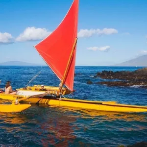 Group paddling Hawaiian outrigger canoe on ocean