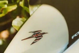 Single short surfboard resting on sandy beach
