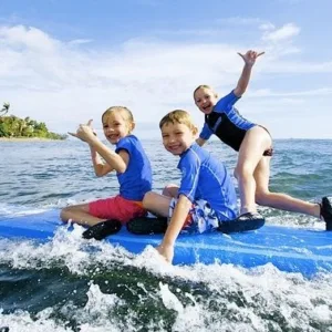 Child learning to surf with instructor in Hawaii