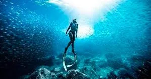 Person learning freediving techniques in Hawaiian ocean waters