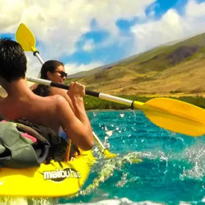Kayakers paddling on calm waters near Maui shoreline