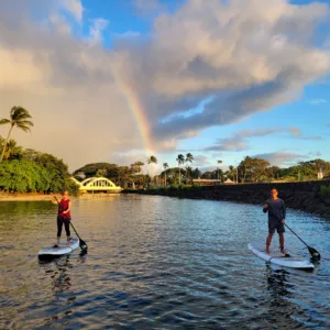 Paddlers on river during Hawaiian sunset