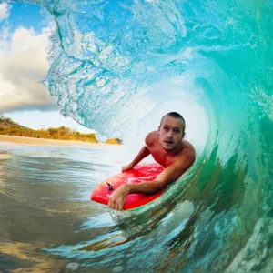 Colorful body boards lined up on sandy beach