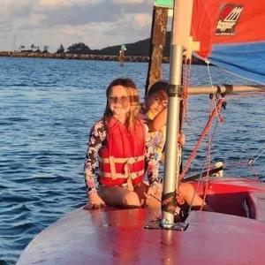 Older keiki practicing sailing skills on water