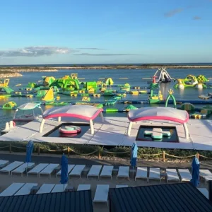 Children playing on floating splash pad in lagoon