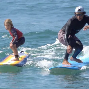 Children learning to surf on gentle waves