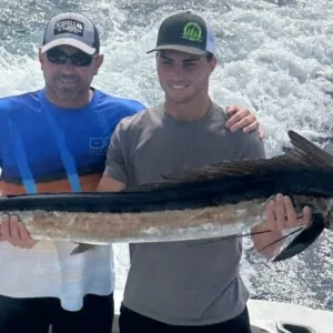 Fishing charter boat cruising Kona coastline waters