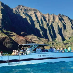 Boat cruising along Na Pali Coast cliffs